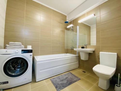 a bathroom with a washing machine and a toilet at Rivera Apartments - Premium Accomodation in Iaşi