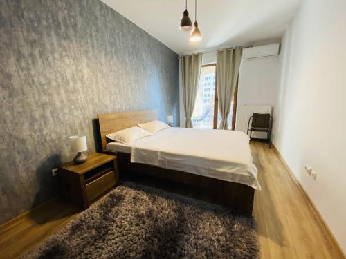 1 dormitorio con 1 cama grande y 1 alfombra en Rivera Apartments - Premium Accomodation en Iaşi