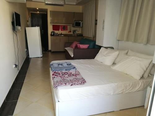 uma grande cama branca num quarto com uma cozinha em Cecilia Beach Resort em Hurghada