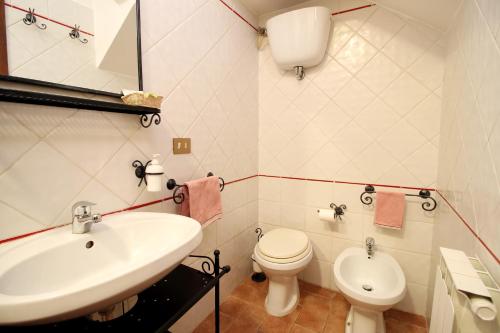 Baño blanco con lavabo y aseo en Monolocale l'Anfiteatro Romano, en Asís