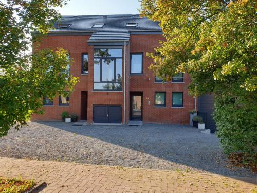 une maison en briques avec une allée en face de celle-ci dans l'établissement Le Berc'AYE, à Aye