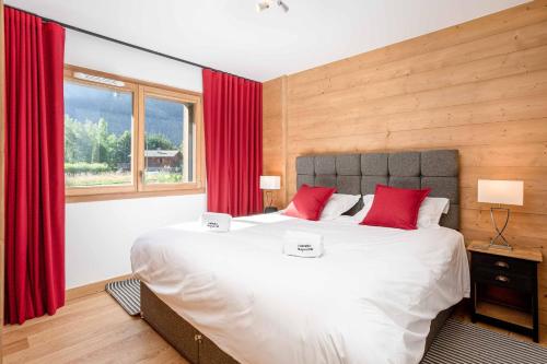 - une chambre avec un grand lit et des rideaux rouges dans l'établissement Coin des Drus Apartment - Chamonix All Year, à Chamonix-Mont-Blanc
