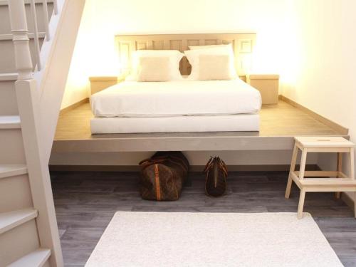 Un dormitorio con una cama blanca y una escalera en Maison Bacou N1, en Carcassonne