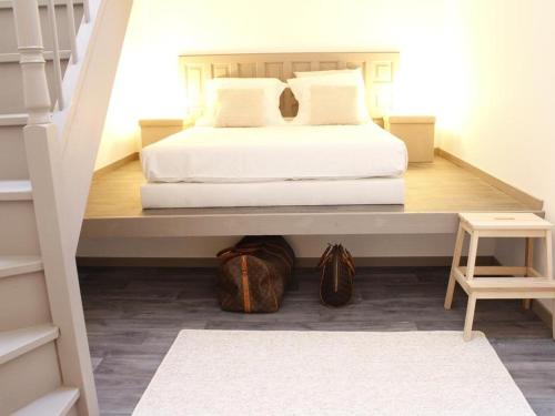 a bedroom with a white bed and a staircase at Maison Bacou N1 in Carcassonne