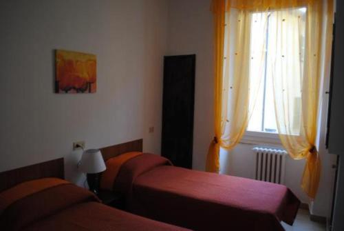 a hotel room with two beds and a window at Hotel La Torretta in Foligno