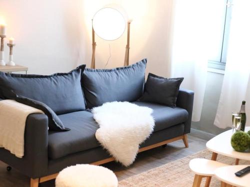 ein Wohnzimmer mit einem blauen Sofa und einem weißen Teppich in der Unterkunft Maison Bacou Cité 3 in Carcassonne