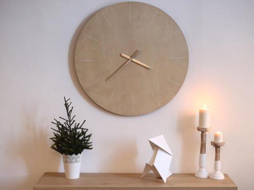 a clock on a wall with a plant and candles at Maison Bacou Cité 3 in Carcassonne