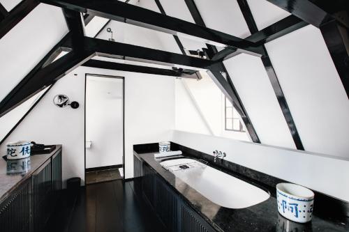 a bathroom with a sink and a large window at The Dylan Amsterdam - The Leading Hotels of the World in Amsterdam