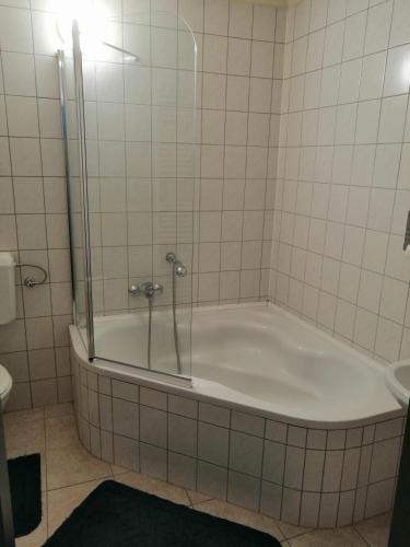 a bath tub in a bathroom with a shower at Kisfaludy Vendégház -Sümeg- in Sümeg