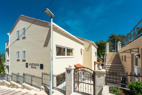 a white building with a street light in front of it at Apartments Rilovic, City and Sea view apartments in Cavtat