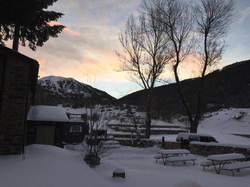 a snowy yard with picnic tables in the snow at Mountain Hostel Tarter in El Tarter