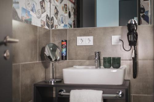 a bathroom with a sink and a phone on the wall at Holiday Inn - the niu, Coin Frankfurt Ostend by IHG in Frankfurt/Main