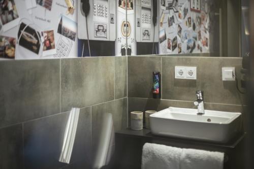 a bathroom with a sink and some pictures on the wall at Holiday Inn - the niu, Coin Frankfurt Ostend by IHG in Frankfurt/Main