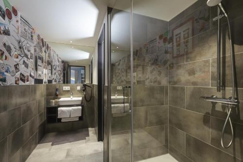 a bathroom with a shower and a glass shower stall at Holiday Inn - the niu, Coin Frankfurt Ostend by IHG in Frankfurt/Main