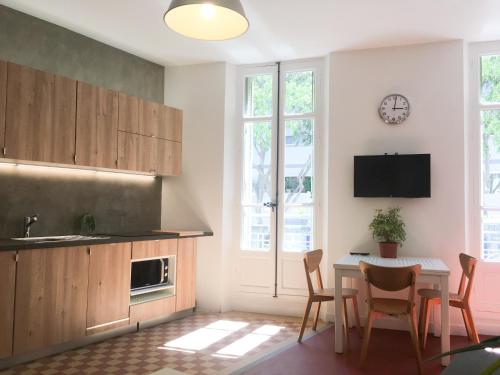 eine Küche mit einem Tisch und Stühlen sowie einer Uhr an der Wand in der Unterkunft Your Home in Marseille*** in Marseille