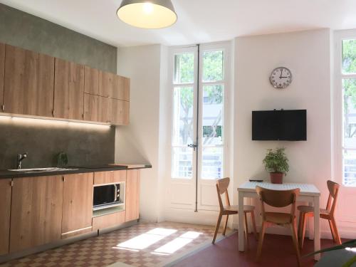 une cuisine avec une table, des chaises et une horloge murale dans l'établissement Your Home in Marseille***, à Marseille