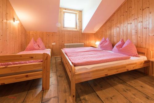 2 Betten in einem Zimmer mit Holzwänden in der Unterkunft Almliesl MITT-396 in Mittersill
