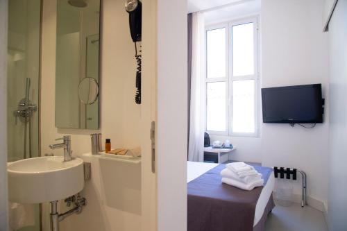 a bathroom with a sink and a bed and a window at Residenza Pantaleo in Rome