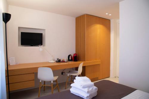 Habitación con escritorio con 2 sillas y TV. en Residenza Pantaleo en Roma