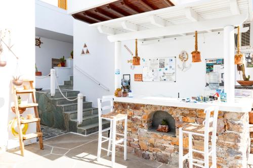 a kitchen with a stone fireplace and stools at Irini pension in Platis Yialos Sifnos