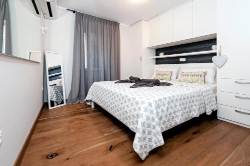 um quarto com uma cama com uma colcha branca em Nel Centro City Apartment em Rovinj