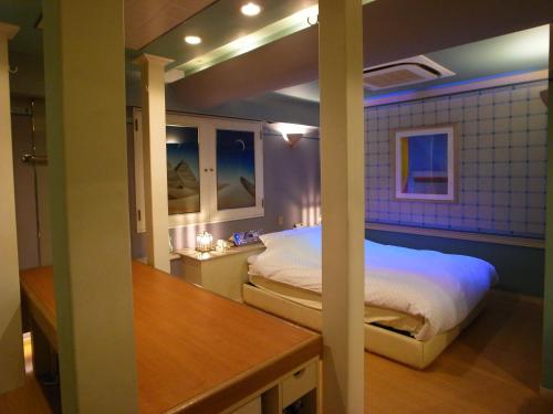 1 dormitorio con 1 cama y 1 mesa en una habitación en HOTEL K VILLAGE en Tokorozawa