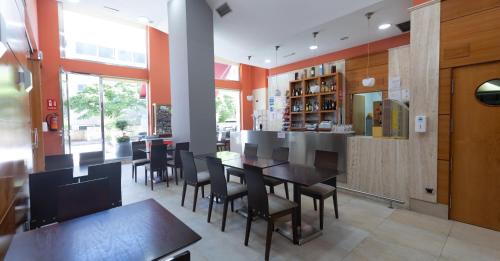 une salle à manger avec des tables et des chaises dans un restaurant dans l'établissement Hotel Apartamentos Ciudad de Lugo, à Lugo