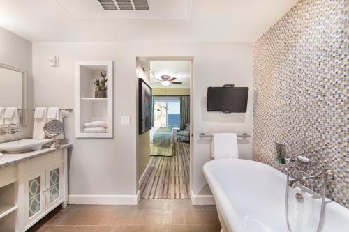 TV y baño con bañera y lavabo. en Holiday Inn Club Vacations Galveston Beach Resort, an IHG Hotel, en Galveston