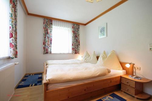 Schlafzimmer mit einem Bett und einem Fenster in der Unterkunft Almliesl TAXE-398 in Taxenbach
