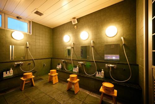 a bathroom with three sinks and three mirrors at Super Hotel Saitama Omiya West in Saitama