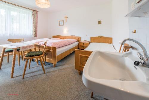 ein Bad mit einem Bett, einem Waschbecken und einer Badewanne in der Unterkunft Almliesl SAAL-097 in Saalfelden am Steinernen Meer