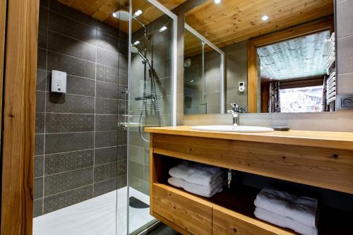 a bathroom with a sink and a shower at Hotel Les Bruyères in Morzine