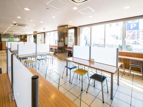 a classroom with tables and chairs and windows at Super Hotel Saitama Omiya West in Saitama