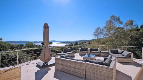 a patio with a couch and an umbrella on a deck at Villa Alinea in Sainte-Maxime