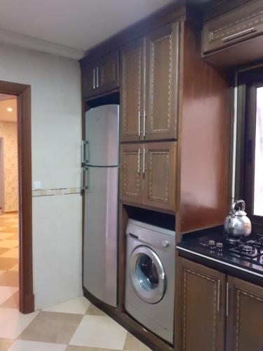 a kitchen with a refrigerator and a washing machine at Residence La corniche Étage 4 in Nador
