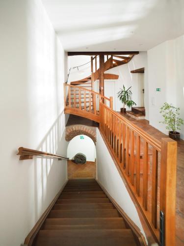 a staircase in a building with a wooden railing at Penzion Kamenne Slunce in Telč