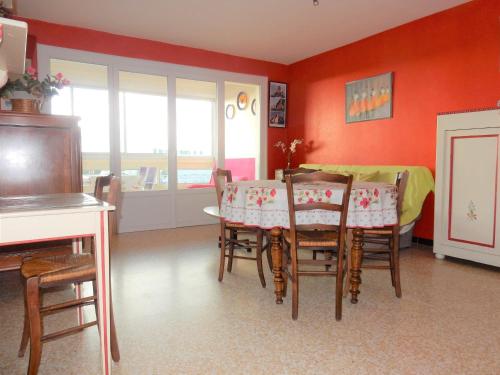 ein Esszimmer mit einem Tisch, Stühlen und roten Wänden in der Unterkunft T2 vue mer quartier calme Grau du roi in Le Grau-du-Roi