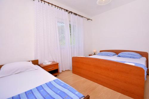 a bedroom with two beds and a window at Apartments Bjanka in Žuljana