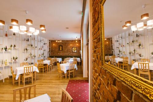 comedor con mesas blancas y espejo en Casa Del Sole en Alba Iulia