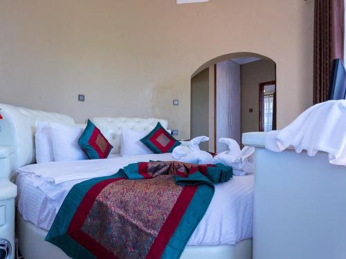 a bedroom with two beds with white sheets at Comfort Gardens Sweetwaters in Nanyuki