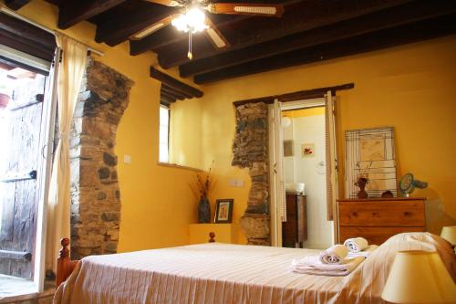 - une chambre avec un lit et des serviettes dans l'établissement Aperanti Agrotourism, à Pera Orinis