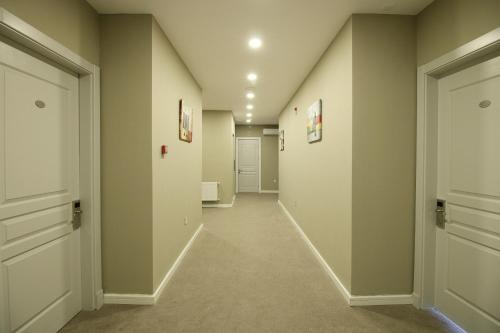 a hallway with white walls and white doors at Tour-ZamZam-Madinah Halal Hotels Group in Baku