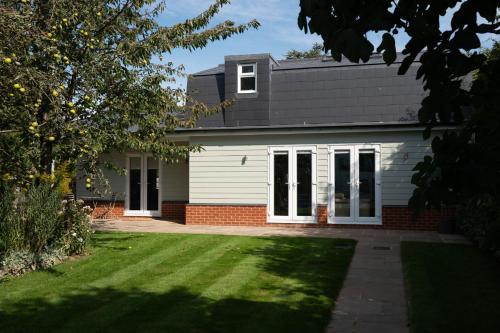 a white house with a black roof at Garden Villa in Cambridge