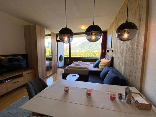 a living room with a table and a couch and a television at Alpenblick Suite in Bad Goisern