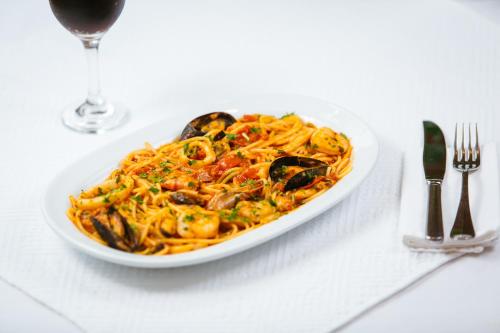 a plate of pasta with mussels on a table at Casa Del Sole in Alba Iulia