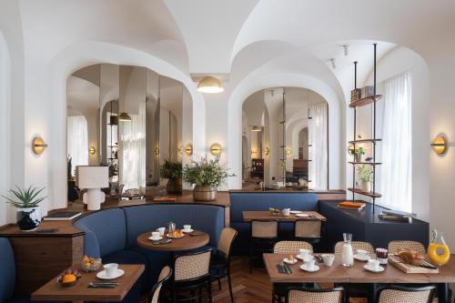 a restaurant with tables and chairs and mirrors at Hotel Le Friedland in Paris