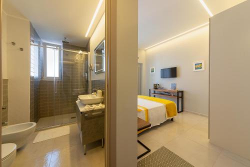 uma casa de banho com uma cama, um lavatório e um chuveiro em B&B La Piazzetta em Ischia