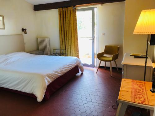une chambre avec un lit, un bureau et une fenêtre dans l'établissement GOLF CLUB D'UZES, à Uzès