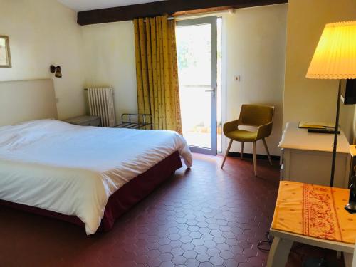 于捷斯的住宿－GOLF CLUB D'UZES，一间卧室配有一张床、一张书桌和一个窗户。