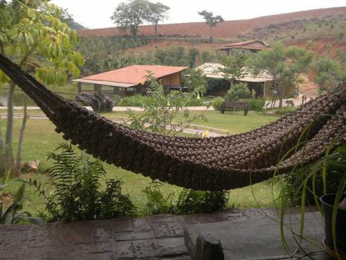 a hammock in the middle of a garden at Pousada Recanto da Siriema in Monte Alegre do Sul